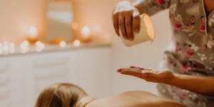 Óleo de massagem sendo despejado na mão antes de uma sessão de massagem sensual